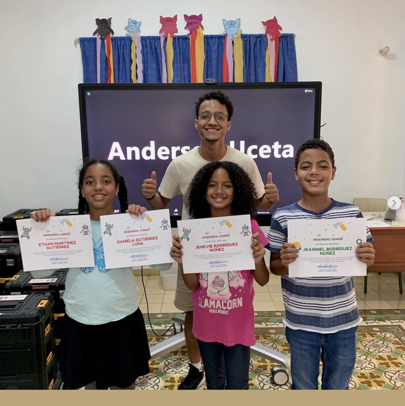 Estudiantes graduados con certificados junto a su instructor